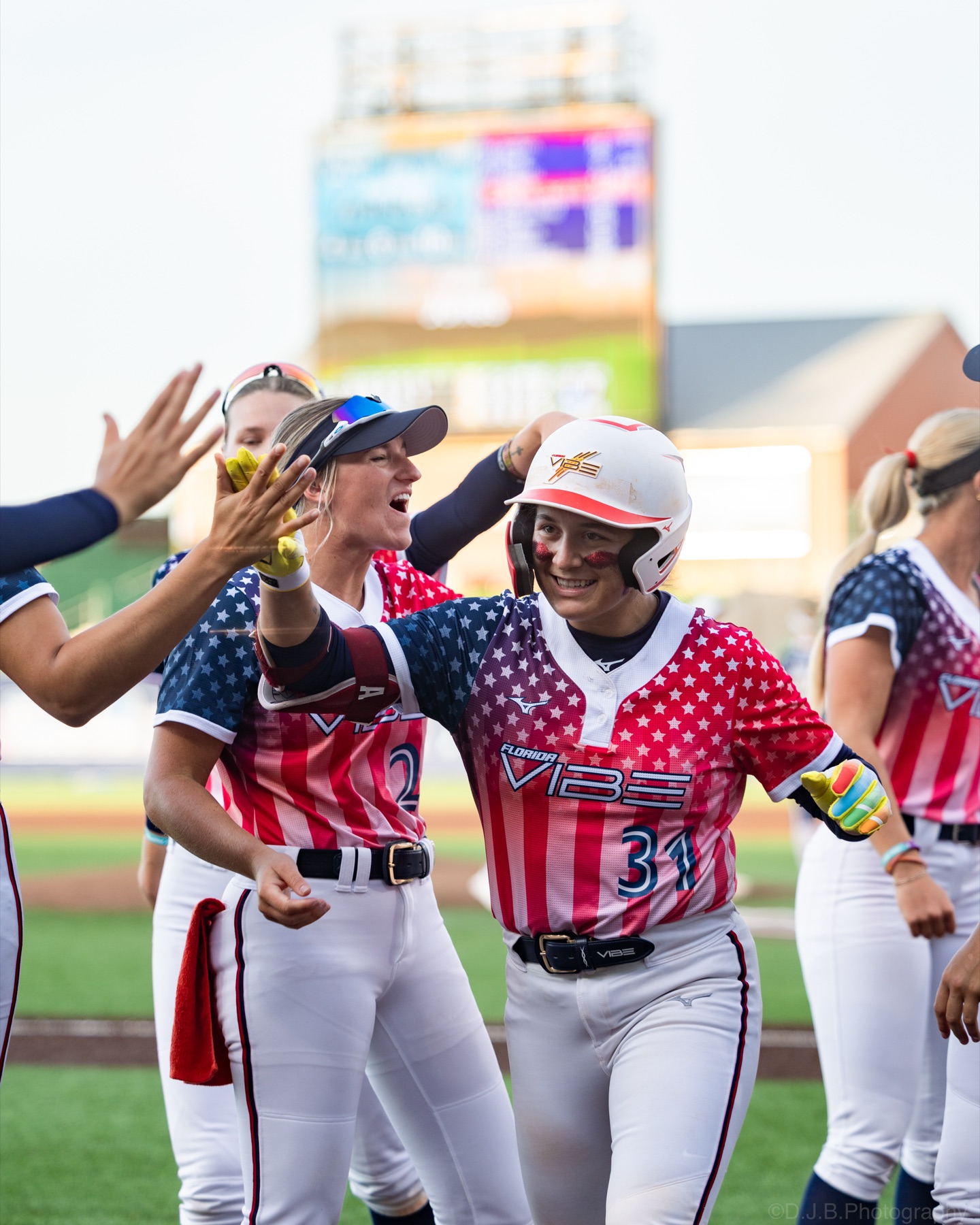 Florida Vibe players high-fiving a smiling teammate as she comes off the field